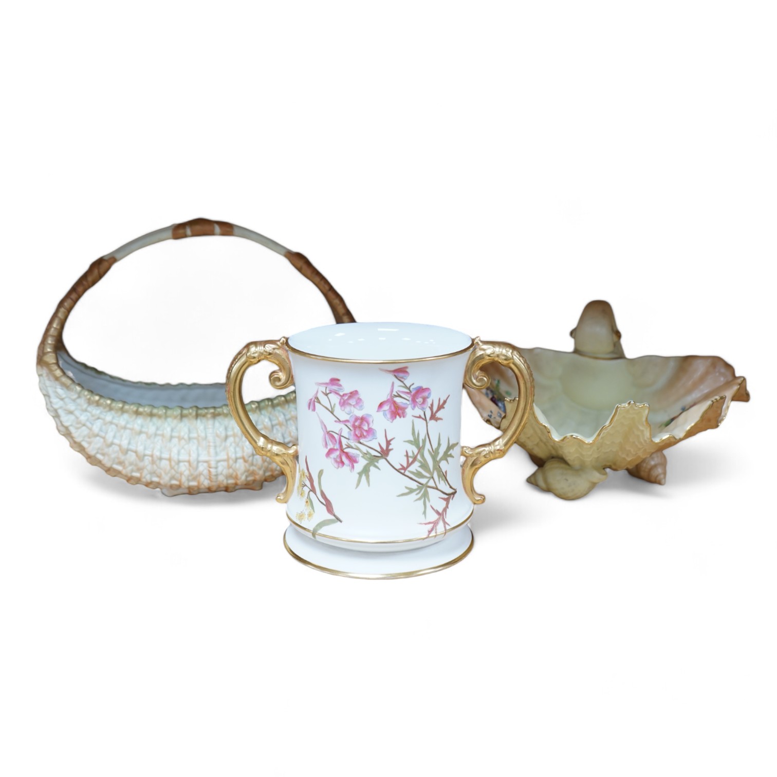 A Royal Worcester blush ivory basket, a shell dish and an ivory coloured two handled mug, 15.5cm (3). Condition - fair to good